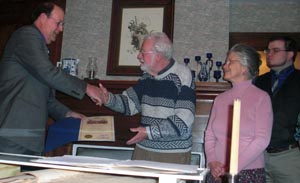 Director Daniels presenting Bob and Irene Fagan with the Bicentennial Farm certificate (the record book is in the foreground)